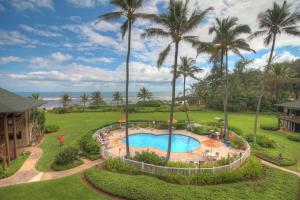 an aerial view of a resort pool with palm trees at Oceanfront 1 BR Condo at Kaha Lani KL309 in Kapaa