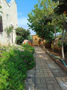 einen Gehweg in einem Garten mit Blumen und Bäumen in der Unterkunft Hephaestus Villa in Kapparianá