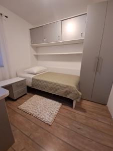 a small bedroom with a bed and a small rug at Apartment Mira in Šibenik
