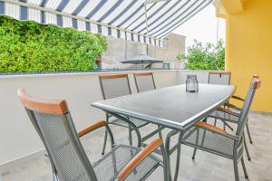 a table and chairs on a balcony with an umbrella at Holiday homEna with a heated pool in Bibinje