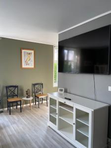 a living room with a flat screen tv on a wall at 1St Floor Oasis - Parking/WiFi in Stavanger