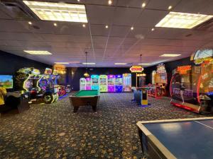 ein Zimmer mit mehreren Arcade-Spielen und einem Billardtisch in der Unterkunft Townhome w pool near Disney & Orlando Attractions in Kissimmee