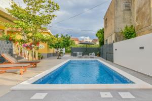 a swimming pool in the backyard of a house at Holiday homEna with a heated pool in Bibinje