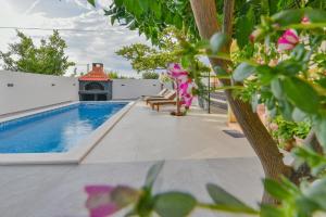 a swimming pool on the side of a house at Holiday homEna with a heated pool in Bibinje