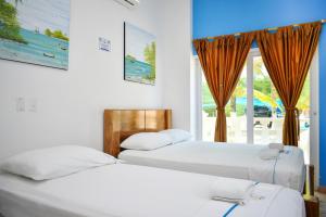 科韋尼亞斯的住宿－Hotel Isla Mágica，带窗户的客房内的两张床