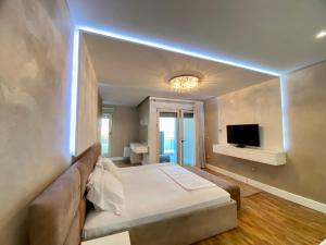 Zimmer mit einem Bett, einem Sofa und einem TV in der Unterkunft Reina Suite in Durrës