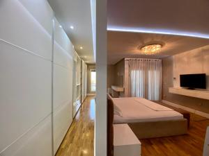 1 dormitorio con 1 cama y 1 habitación con TV en Reina Suite en Durrës