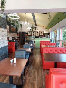 a restaurant with red chairs and tables and benches at Apartament i pokoje u Roberta in Polańczyk
