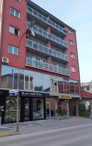 ein rotes Gebäude auf der Straßenseite in der Unterkunft Apartmani blue i green in Bugojno