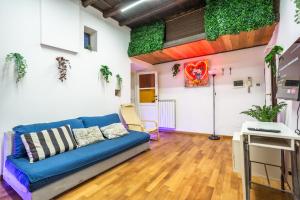 salon z niebieską kanapą i roślinami w obiekcie The Magic Hole w Rzymie