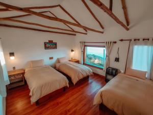 - une chambre avec 2 lits et une fenêtre dans l'établissement Ecolodge K'arasirca, à Comunidad Yumani