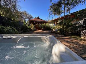 uma banheira de hidromassagem num quintal com uma casa em Te Ariki - Adults Only em Hanga Roa