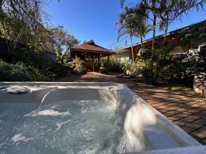 una bañera de hidromasaje en un patio con una casa en Te Ariki - Adults Only, en Hanga Roa