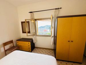 een slaapkamer met een bed, een raam en een spiegel bij La Donzella - Immobilevante in Ponza