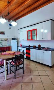a kitchen with white cabinets and a table in it at Il Principe casa vacanze in Trabia