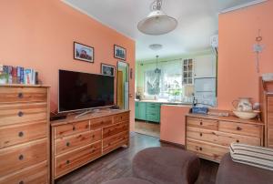 uma sala de estar com televisão numa cómoda de madeira em LiliHome em Gárdony
