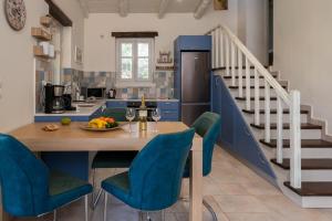 a kitchen with a wooden table and blue chairs at Villa Amit in Sivota