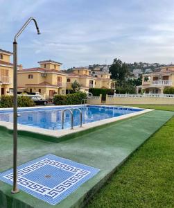 a swimming pool in a yard with a street light at Los Alamos Somhome in Peñíscola