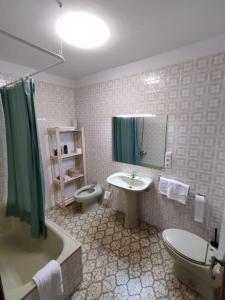La salle de bains est pourvue d'un lavabo, de toilettes et d'une baignoire. dans l'établissement Acogedor piso en primera línea de mar- 8 huéspedes, à A Guarda