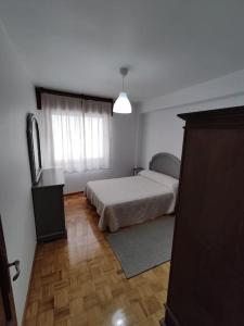 - une chambre avec un lit et une fenêtre dans l'établissement Acogedor piso en primera línea de mar- 8 huéspedes, à A Guarda
