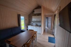 a kitchen and dining room in a tiny house at Kwiatkowo - całoroczny kompleks z baliami i letnią plażą in Radków