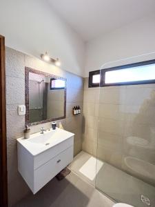 a bathroom with a sink and a glass shower at Casa Vergara I in Villa Unión