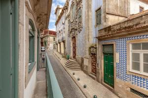 eine Gasse in einer Altstadt mit grünen Türen in der Unterkunft Dasi House in Porto