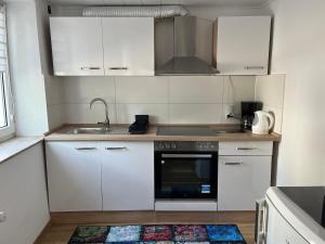a kitchen with white cabinets and a sink at Zur Guten Stube - Self Check In- 