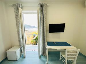 a room with a desk and a tv and a window at Sky Ponza - Immobilevante in Ponza