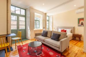 - un salon avec un canapé et un tapis rouge dans l'établissement Dasi House, à Porto