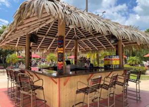 un bar con sillas y una sombrilla de paja en Relaxing resort, spacious pool near Disney en Davenport