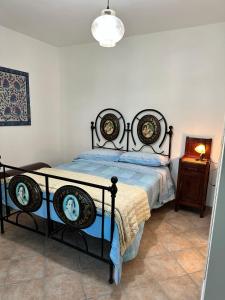 een slaapkamer met een zwart bed en een blauw dekbed bij La Casa Dei Fagiani in Foligno