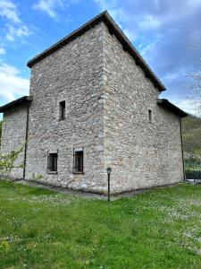 een groot stenen gebouw in een grasveld bij La Casa Dei Fagiani in Foligno