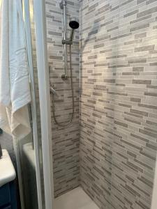 a bathroom with a shower with a brick wall at La Casa Dei Fagiani in Foligno