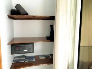 eine Mikrowelle auf einem Regal in einem Zimmer in der Unterkunft TAHITI - Studio Ata in Pirae