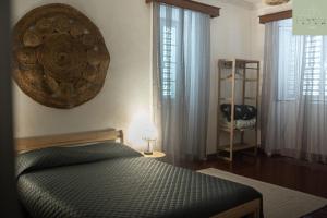 ein Schlafzimmer mit einem Bett, einem Regal und Fenstern in der Unterkunft Casa das Hortas in Vila Franca do Campo