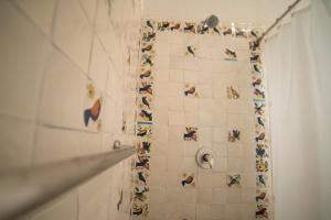 a bathroom with a shower with tiles on the wall at Villa Mirasol in San Miguel de Allende