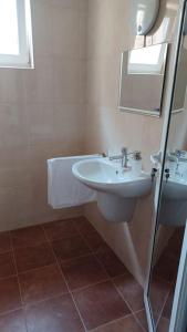 ein Badezimmer mit einem weißen Waschbecken und einem Spiegel in der Unterkunft ARIA in Primorsko
