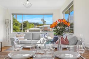 uma sala de jantar com uma mesa com um vaso de flores em Sunny Inn Tawavale em Rotorua