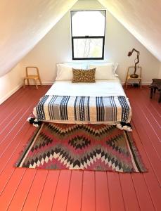 a bedroom with a bed with a rug on the floor at Inn Paradiso in Paso Robles