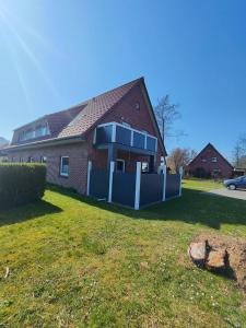 a house with a blue fence in front of it at Familien Apartments in bester Lage in Butjadingen