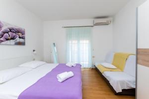 a white room with a bed and a chair at Apartment Miljenko in Lopar