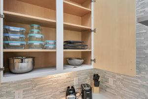 a kitchen cabinet with plates and bowls in it at Mohr Haus - Walk to NRG Stadium - Medical Center - Sleeps 8 in Houston +44 photos