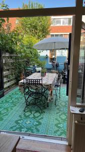 een patio met een tafel en stoelen en een parasol bij BeBaBops Homestay Utrecht in Utrecht