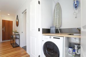 una lavanderia con lavatrice e asciugatrice di Sunny Inn Tawavale a Rotorua