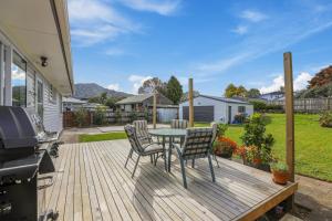 um deque de madeira com uma mesa e cadeiras em Sunny Inn Tawavale em Rotorua