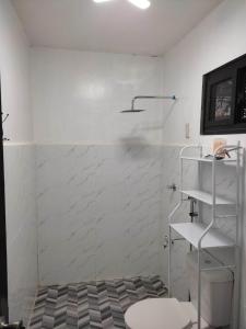 baño con pared blanca y estante en Solwara Beach Resort, en Balete