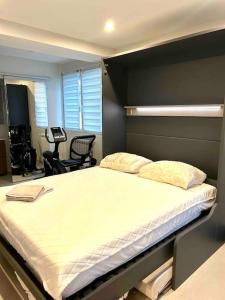 1 dormitorio con 1 cama grande y pared negra en Espace Les Orangers - Piscine - 10mn plages, en Six-Fours-les-Plages