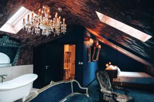 a bathroom with a chandelier and a bed and a tub at Pensão Amor Madam's Lodge in Lisbon