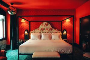 a bedroom with a large bed with red walls at Pensão Amor Madam's Lodge in Lisbon